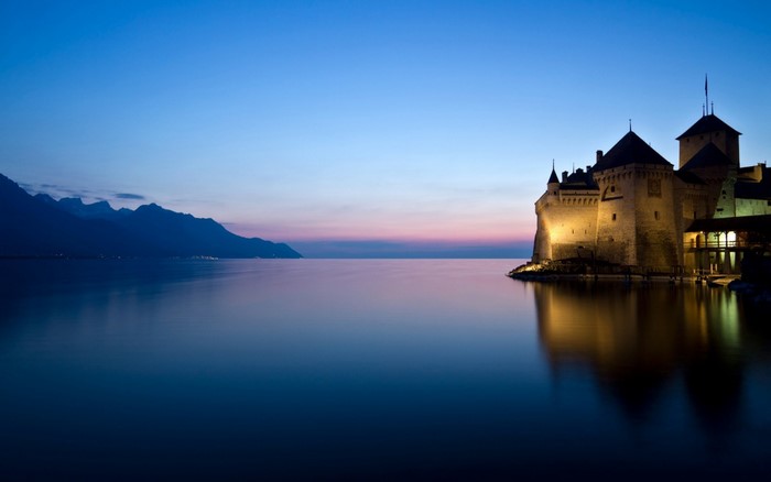 Chillon Castle on a lake at dusk