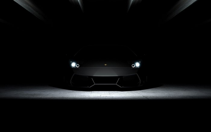 Black Lamborghini sports car with headlights on