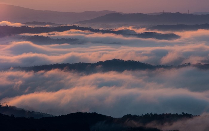 Mountain range covered in mist at sunrise