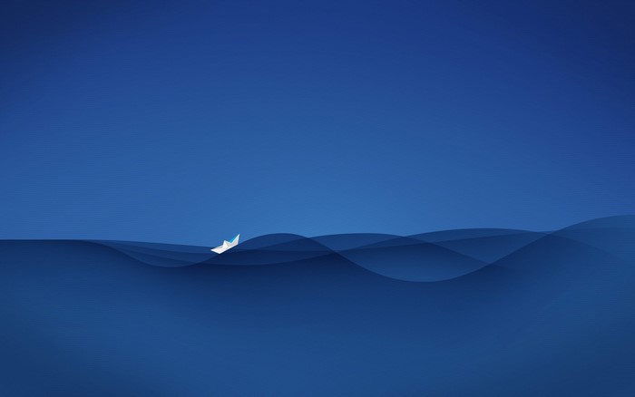Paper boat sailing on blue waves