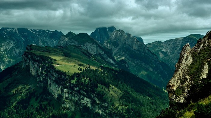 Green mountain range with dramatic clouds