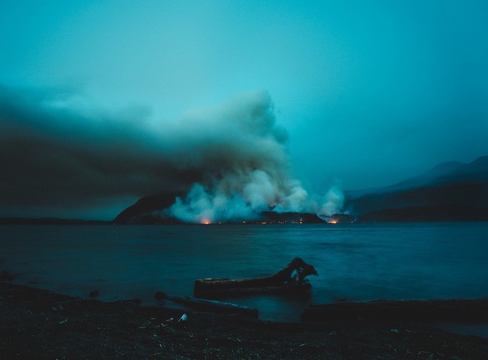 Fire and smoke over a lake at dusk
