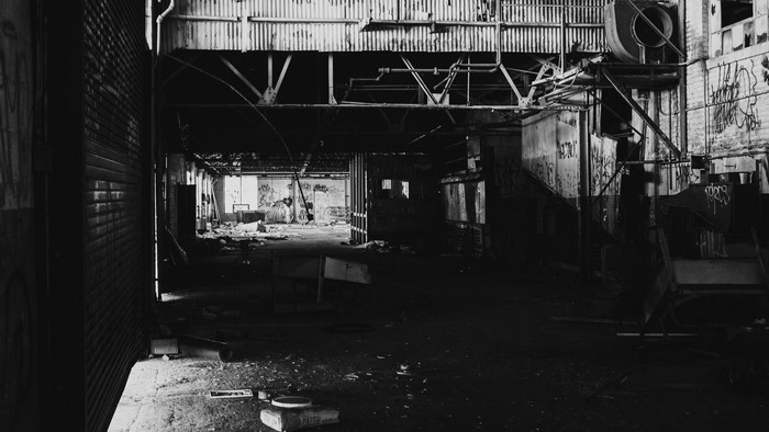 Abandoned factory interior with graffiti and debris