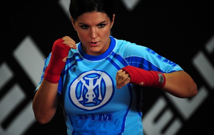 Gina Carano in fighting stance with red hand wraps