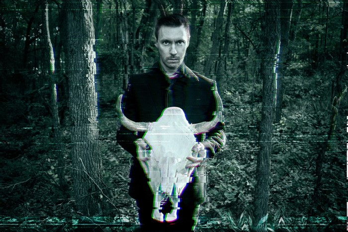 Blue Stahli holding a bull skull in a glitchy forest