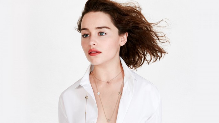 Emilia Clarke wearing a white shirt and necklaces
