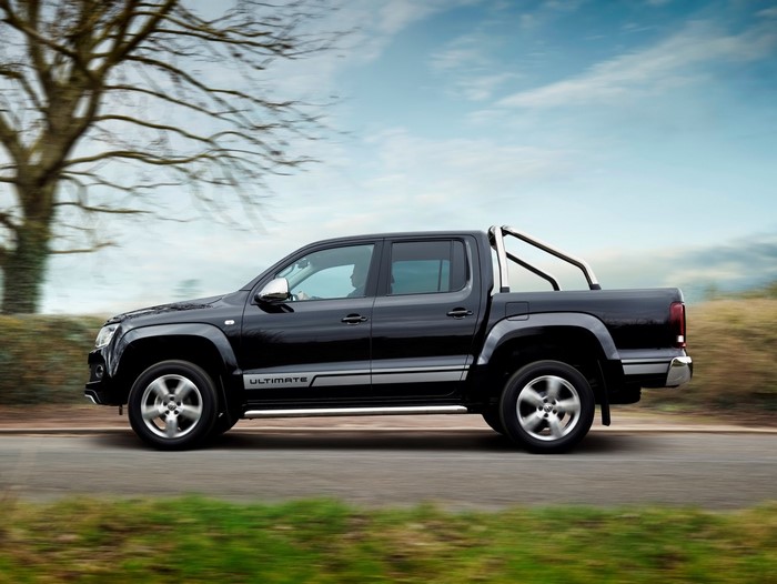 Black Volkswagen Amarok Ultimate pickup truck driving on a road