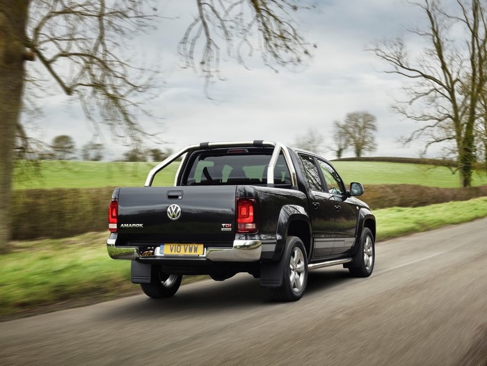 Black Volkswagen Amarok TDI pickup truck driving on a road