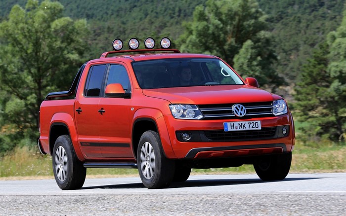Orange Volkswagen Amarok pickup truck driving on a road