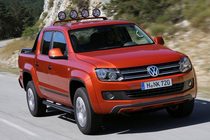 Orange Volkswagen Amarok pickup truck driving on a road