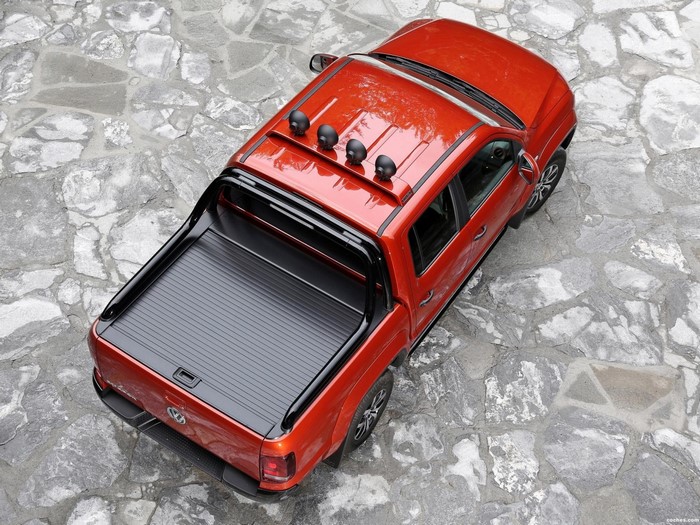 Orange Volkswagen Amarok pickup truck with roll bar