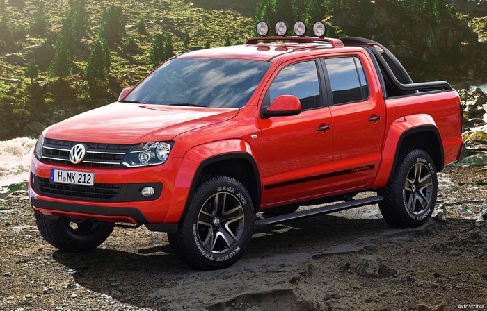 Red Volkswagen Amarok Canyon pickup truck on rocky terrain