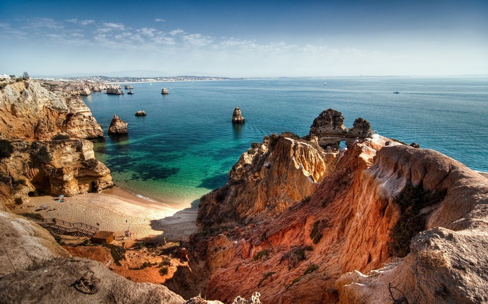 Coastal cliffs overlooking a turquoise ocean and beach