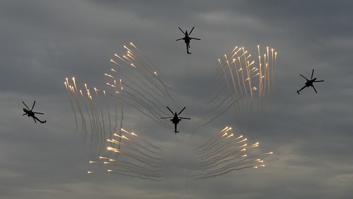Helicopters performing aerial maneuvers with flares