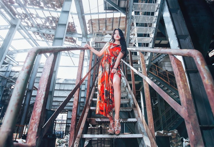 Model in Vibrant Dress Posing on Industrial Staircase