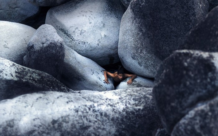 Man climbing between large rocks