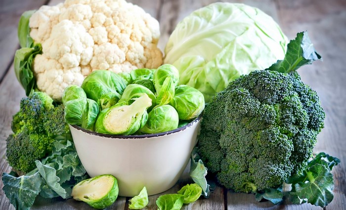 Assortment of fresh cruciferous vegetables on a wooden surface