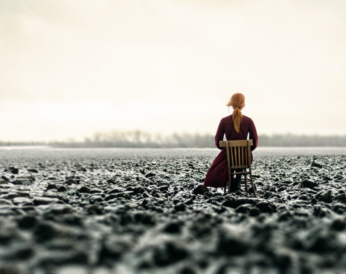 Woman sitting on a chair in a field
