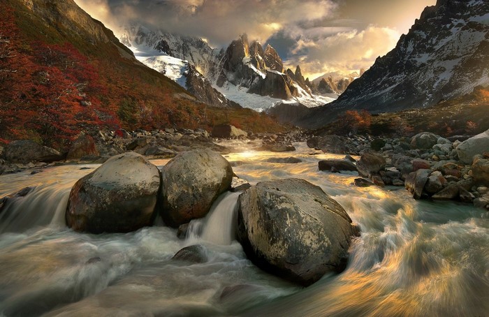 River flowing through a valley with mountains and autumn trees