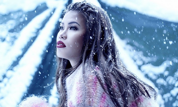 Asian model in snow during winter photoshoot