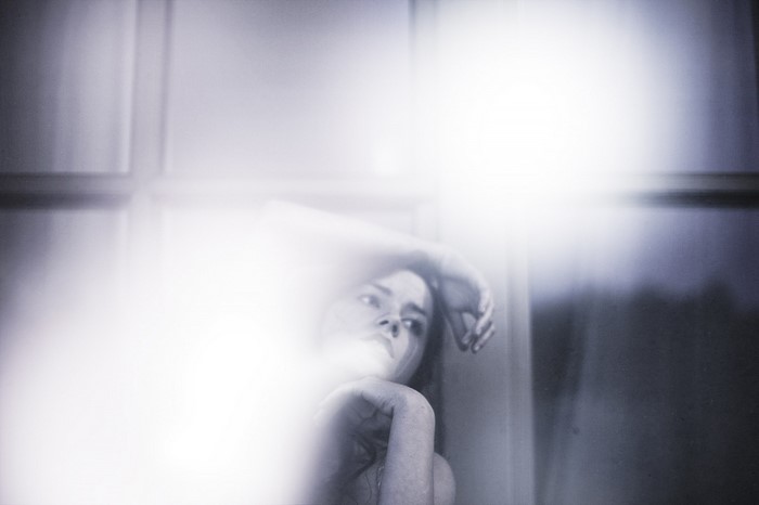 Woman with arm raised in abstract monochrome photography