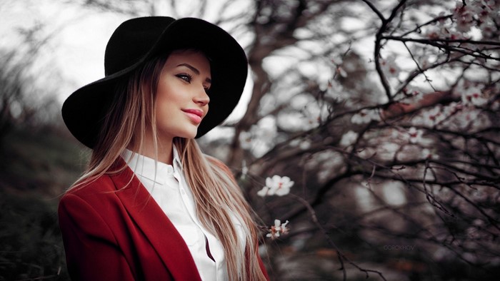 Woman in red jacket and black hat with flowers
