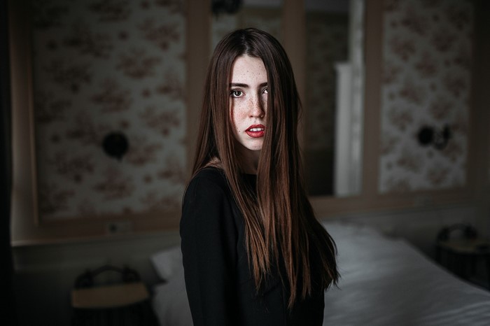 Woman with long brown hair and freckles wearing a black dress