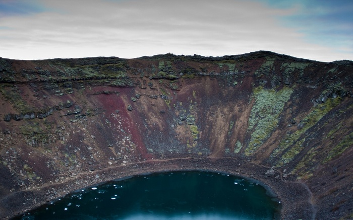 Crater lake with colorful volcanic rock walls