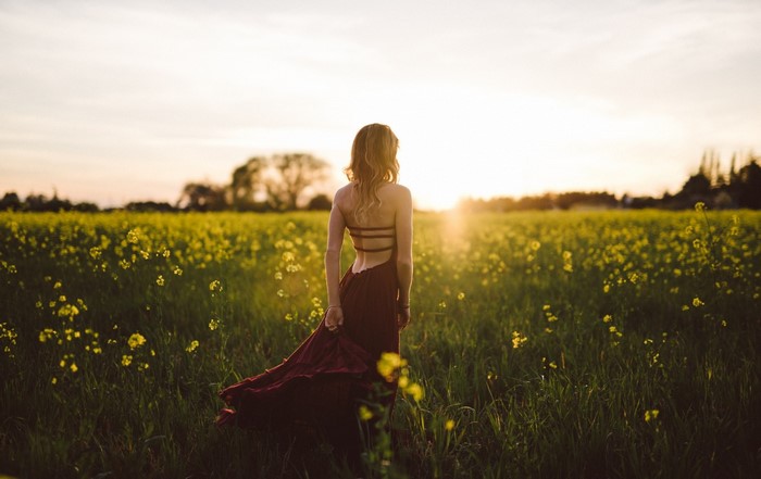 Woman in a dress in a field at sunset