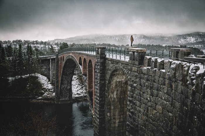 Man on a stone bridge in winter