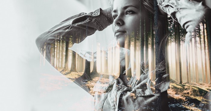 Double exposure of a woman and a forest