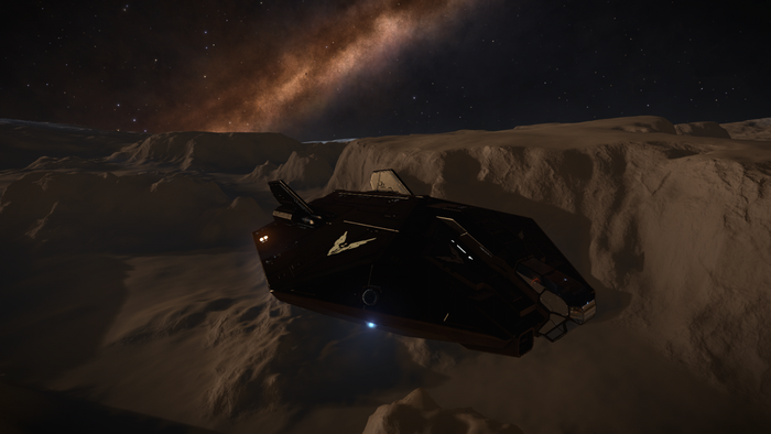Elite Dangerous spaceship flying over a rocky planet at night