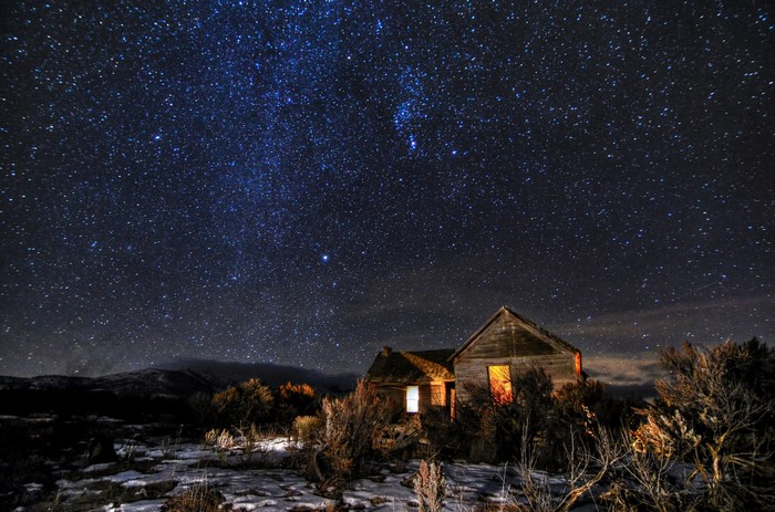 Abandoned houses under a starry night sky