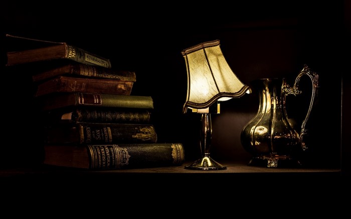 Stack of old books with a lamp and pitcher