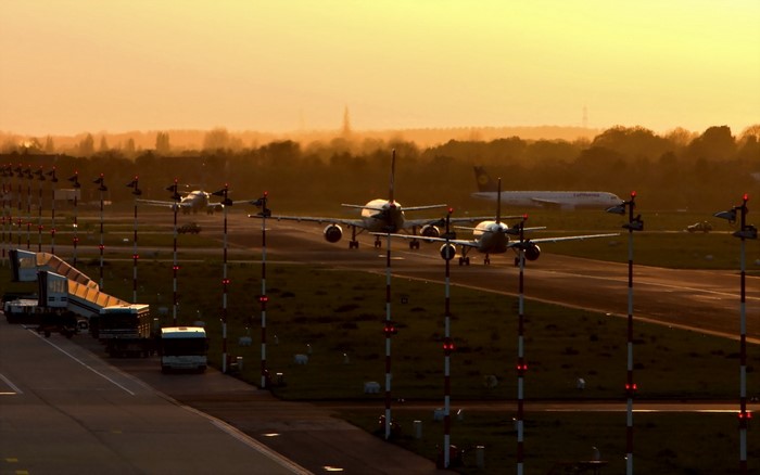 Airplanes on runway at sunset with airport lights