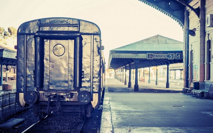 Rear view of a dark train at a railway station platform