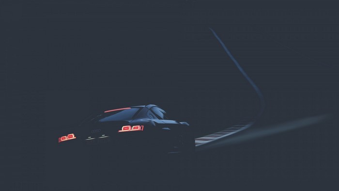 Audi R8 driving on a dark race track at night