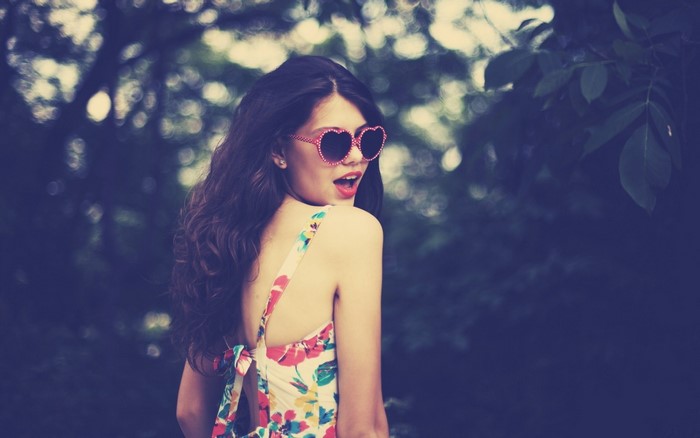 Woman with heart-shaped sunglasses in a floral dress