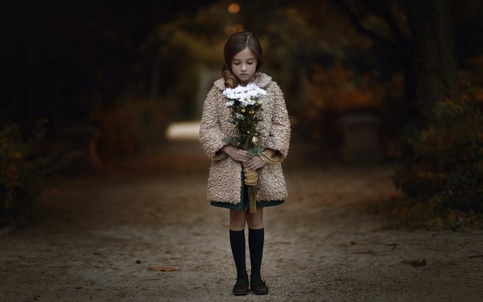 A young girl holding a bouquet of white flowers