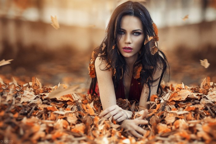 Woman lying in autumn leaves
