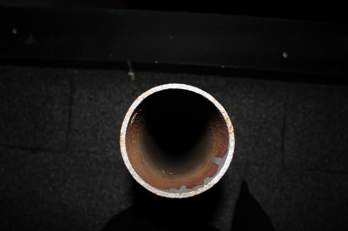 Close-up of a rusty metal pipe opening