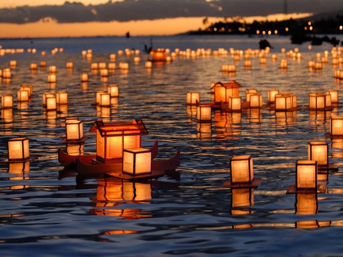 Floating lanterns on the water at sunset