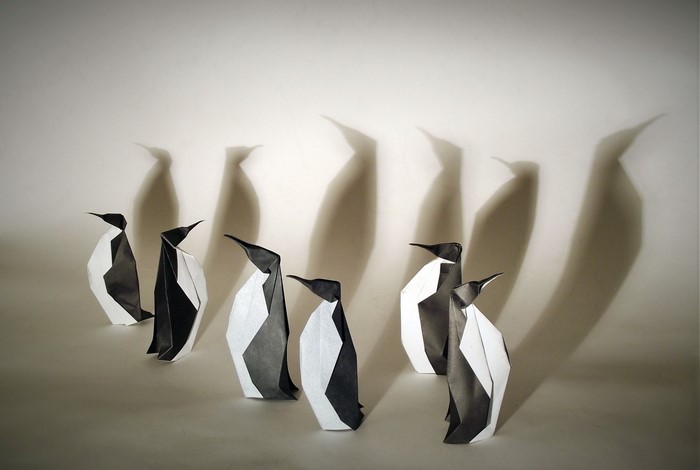 Origami penguins casting shadows