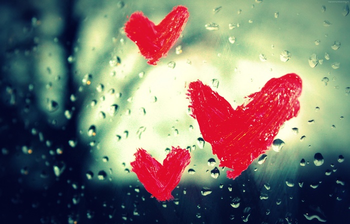 Red hearts painted on a wet window