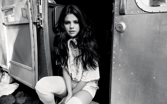 Selena Gomez sitting by an Airstream trailer