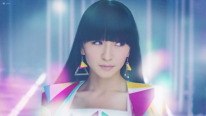 Woman with black hair and geometric earrings