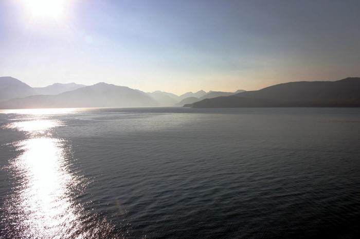 Sunlight reflecting on water with mountains in the background