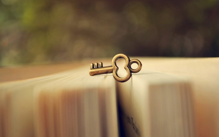 Antique key resting on an open book