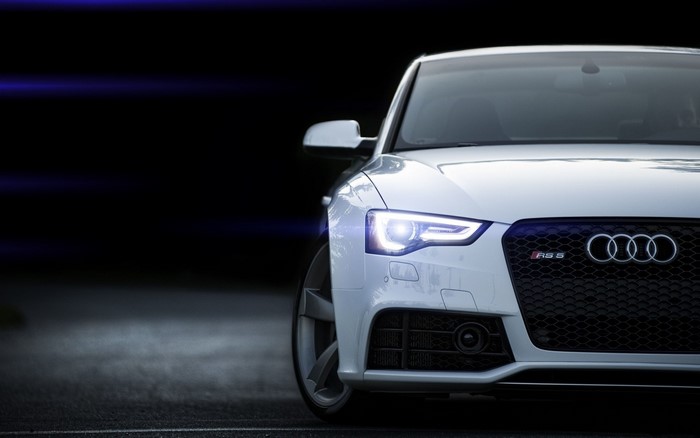 White Audi RS5 sports car with headlights on