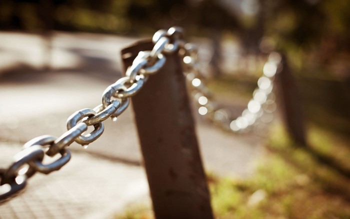 Close-up of a metal chain with bokeh background